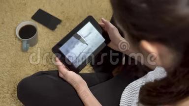 女孩坐在地毯上用平板电脑屏幕观看艺术<strong>素描视频</strong>